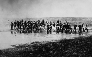 Black and white photo of a battalion in a stream