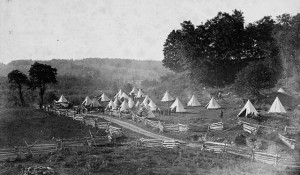 Tents and people assembled in a fenced-in field