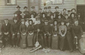 Photo of a uniformed group, some holding musical instruments
