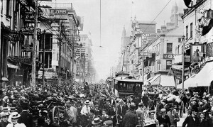 Black and white photo of a city street jam-packed with people