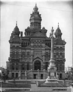 A large ornate building with monument in front