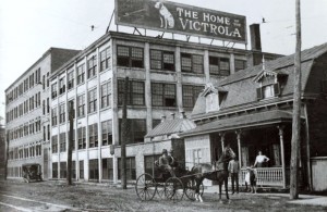 Photo of a factory reading "The home of the Victrola" and a horse-drawn wagon in front