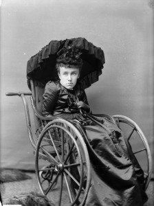 A woman sitting in a wheelchair holding an umbrella