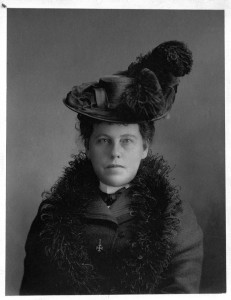Black and white photo of a woman in dark upper-class attire