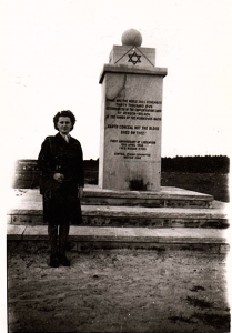A woman stands beside a memorial