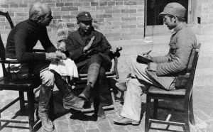 Three seated men in conversation