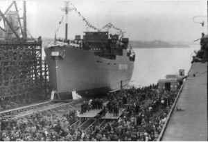 A massive ship is launched into water as crowds look on