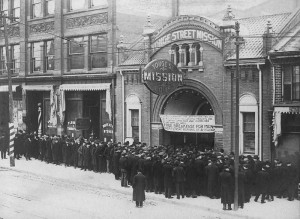 Exterior of Yonge Street Mission with a large crowd and a sign reading "Free breakfast for men"