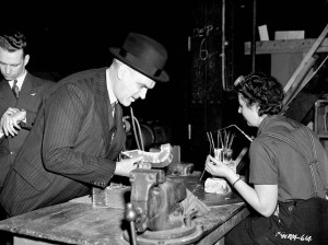 A man leans over a worker's table