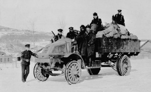 Military men aboard a truck in a snowy landscape