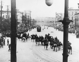 Mounted police move through a street toward crowds
