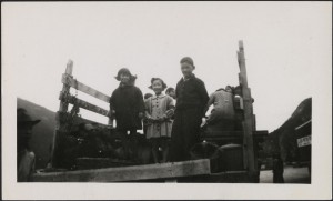Photo of children facing the camera from the back of a truck