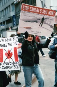 A woman holds a sign reading "Stop Canada's seal hunt"
