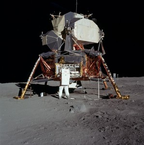 An astronaut stands before a lander on the moon