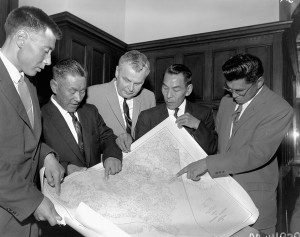 Five men discussing a map