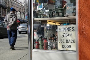 Store window with sign reading "Hippies please use back door"