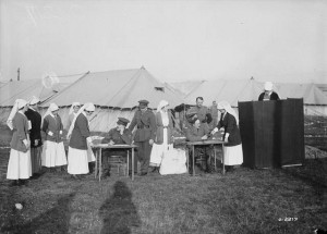 Nuns lined up at tables, with one behind a voting screen