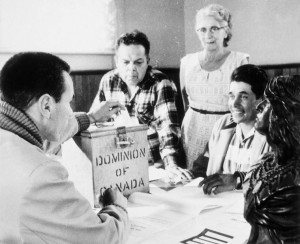 A group gathers around a ballot box reading "Dominion of Canada"