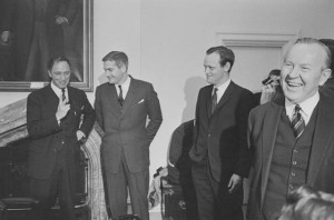 Four smiling men in suits