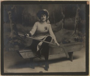 "Benched" collectors' card: a young woman sitting on a bench with a hockey stick