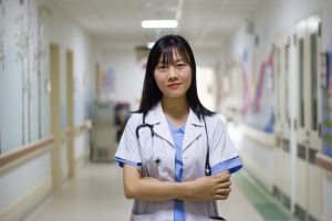 Image of a healthcare student smiling in a hospital clinical placement.