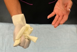 Place inside-out glove in gloved hand