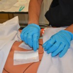 Remove outer dressing with non-sterile gloves