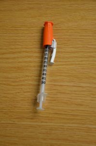 Insulin syringe with needle attached