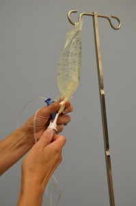 Insert IV spike into sterile solution using sterile technique