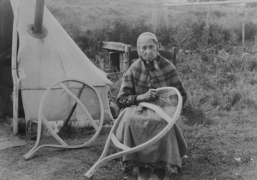 Indigenous woman, possibly Innu, making snowshoes. 