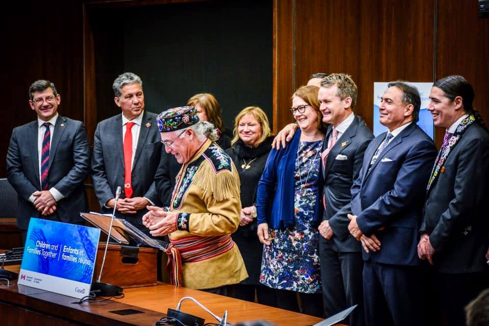 The introduction of Bill C-92 (2019), marking a historic turning point for First Nations, Inuit, and Métis children and families. At podium: Métis National Council President Clement Chartier; Minister of Indigenous Services Jane Philpott, embracing Minister of Indigenous Services Seamus O’Regan, and proceeding to the right: Assembly of First Nations National Chief Perry Bellegarde, Natan Obed, President of Inuit Tapiriit Kanatami. Photo Credits to: GC Indigenous. Text Credits to: Seamus O'Regan.