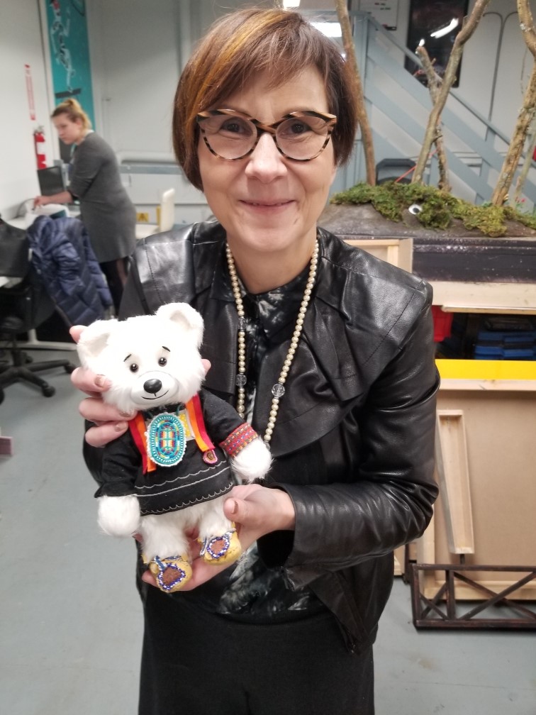 Cindy Blackstock holding up a plush bear like the one which “bears” witness during FNFCS court cases. Used with permission from Cindy Blackstock