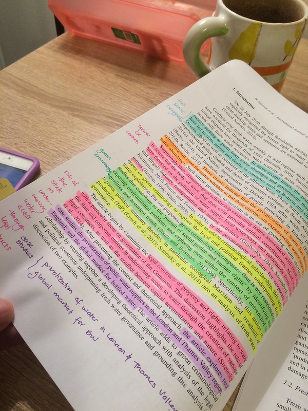 Image of a texbook with passages highlighted in different colours and with notes in the margins