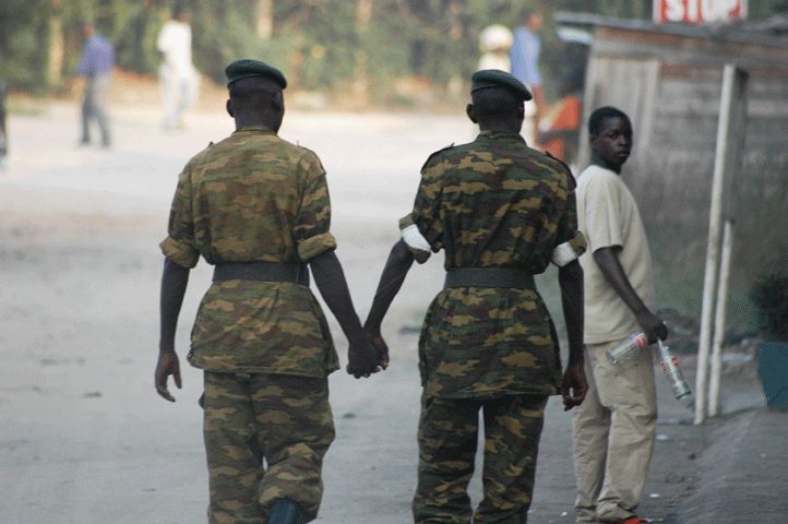 An image of two African soldiers holding hands.