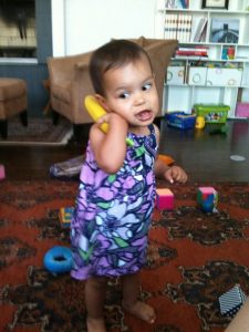 A toddler playing with a toy telephone.