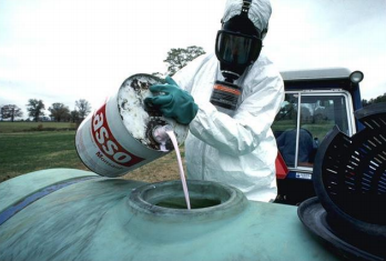 image of an employee pouring a hazardous chemical from a small container into a larger container