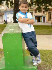 a young boy standing on a raised concrete form with his arms folded