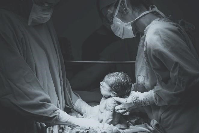 a doctor delivering a baby via a c-section