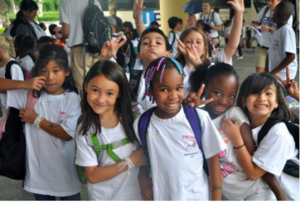 Photo of a group of children at school, smiling for the picture. 