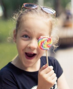 A child holding up a lollipop