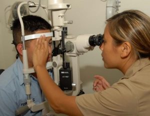 Woman performing an eye exam on a child. 