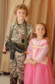 Photo of two children - boy dressed up as a soldier and the girl dressed up as a princess.
