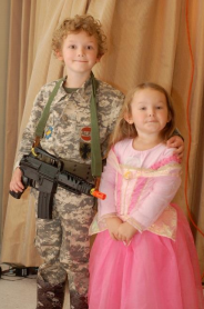 Photo of two children - boy dressed up as a soldier and the girl dressed up as a princess. 