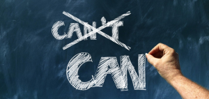 image of a chalkboard with a hand writing in chalk crossing out the word "can't" and writing the word Can