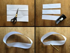 four images of a piece of paper being cut into strips and taped together