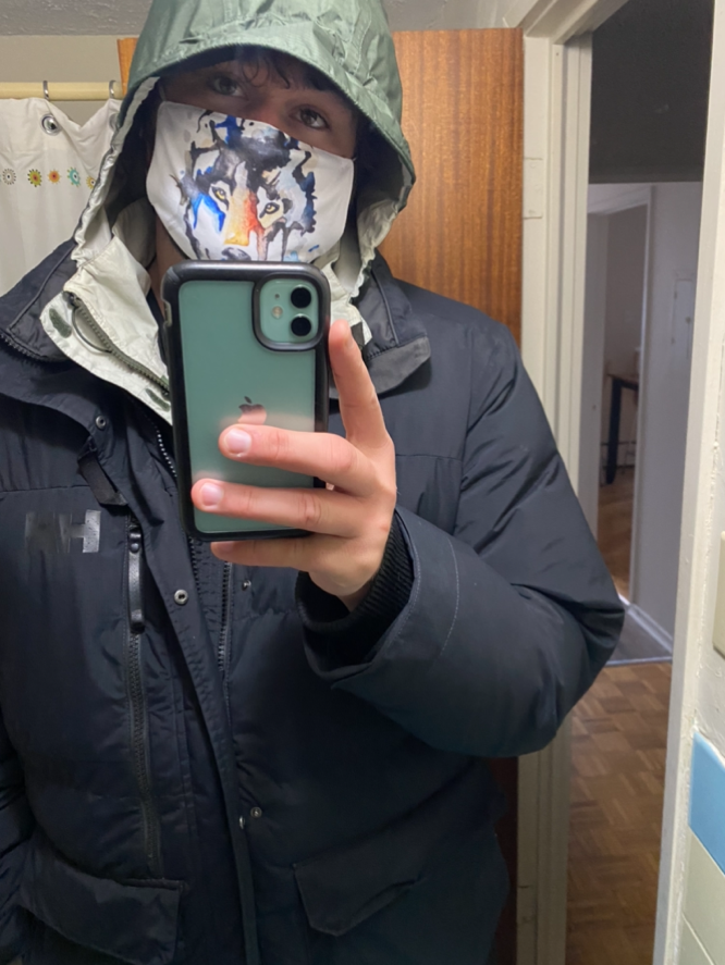 selfie photo of the author wearing a hooded jacket and face mask, holding the camera in the foreground