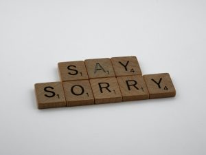 Wooden Scrabble letters that say: Say sorry.
