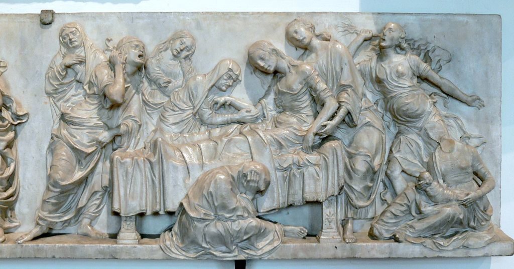 Figure 1-6. A marble relief depicts a women half lying in bed, half being supported by two female attendants. One female attendant holds a baby near the head of the bed, while five other attendants wail in despair around the bed.