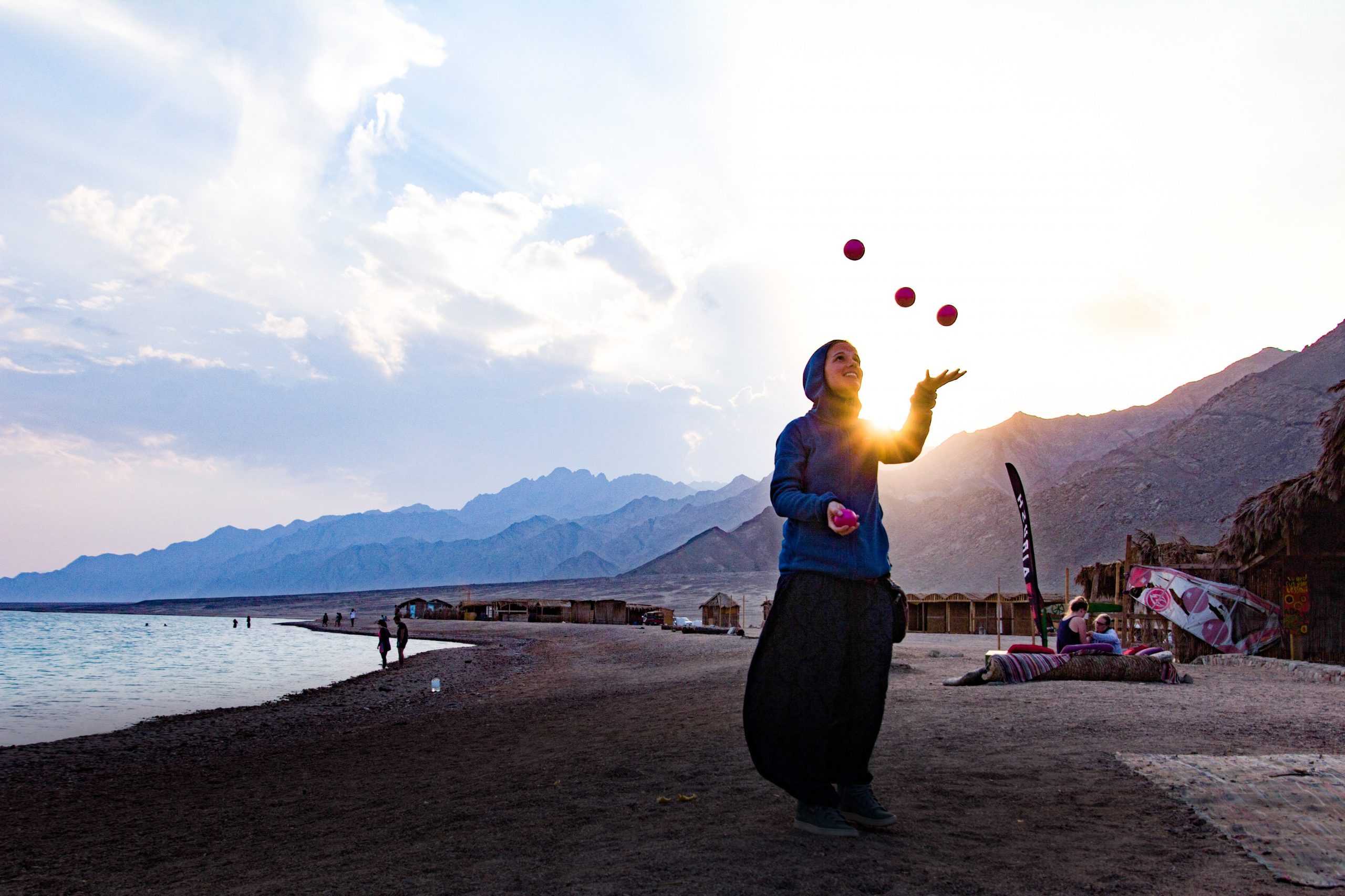 Picture of a woman juggling on a beach