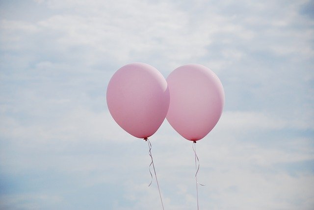 Two balloons floating in the sky